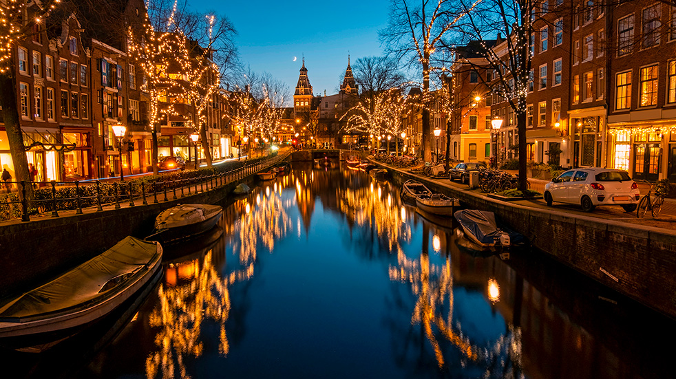 A lit up canal in Amsterdam at night